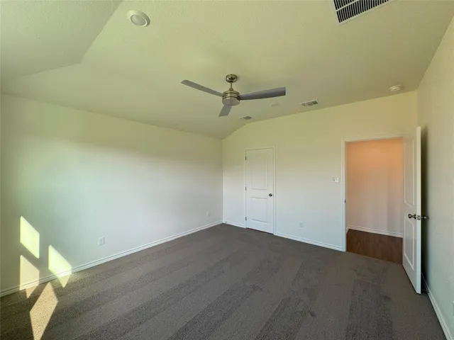 an empty room with a ceiling fan and wooden floor