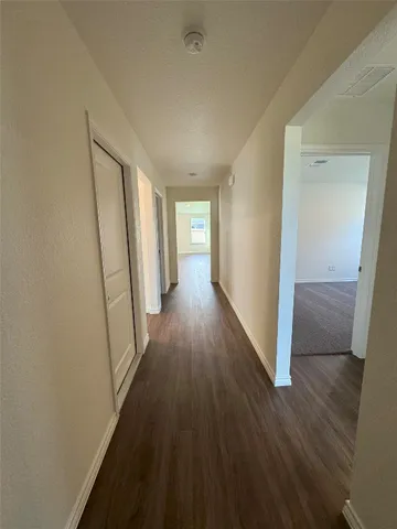 a view of a hallway with wooden floor