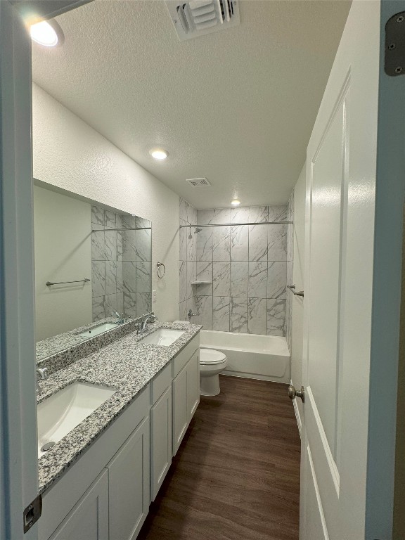 501 Double Vision Road Jarrell, TX 76537 - Photo 21 of 36 a bathroom with a granite countertop sink a toilet a mirror and bathtub