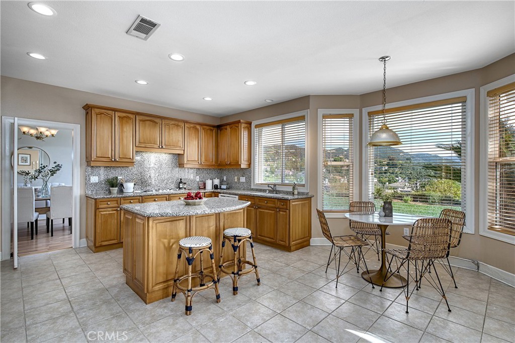 24932 Normans Way Calabasas, CA 91302 - Photo 17 of 63 a kitchen with a stove a refrigerator a sink a dining table and chairs