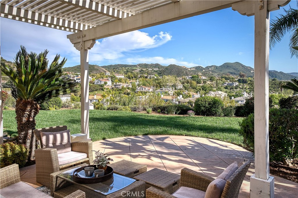 24932 Normans Way Calabasas, CA 91302 - Photo 45 of 63 a view of a patio with table and chairs potted plants and palm tree