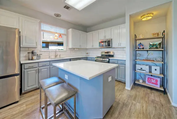 a kitchen with a sink appliances and cabinets
