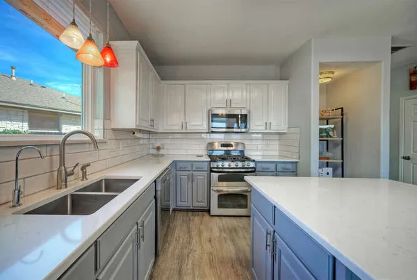 a kitchen with stainless steel appliances granite countertop a sink stove and refrigerator