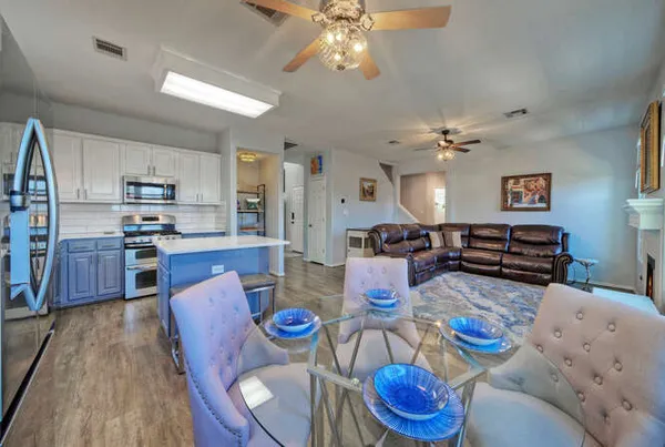 a living room with lots of dining room furniture and kitchen view