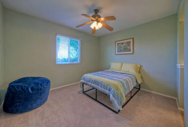 a spacious bedroom with a bed and a chandelier