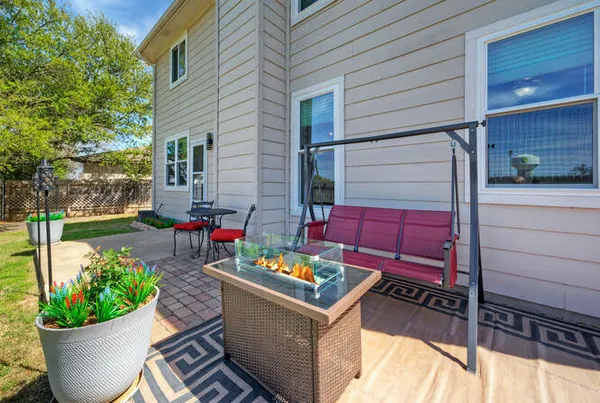 a view of a backyard with chairs and a potted plant
