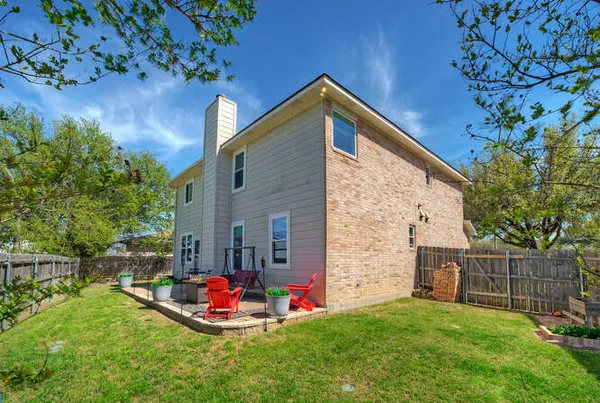 a backyard of a house with table and chairs