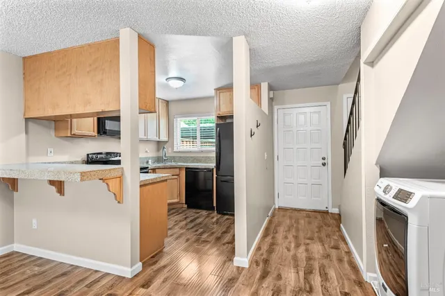 a kitchen with a refrigerator and a stove top oven
