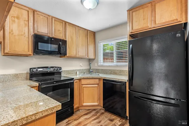 a kitchen with granite countertop stainless steel appliances a stove a sink and a microwave