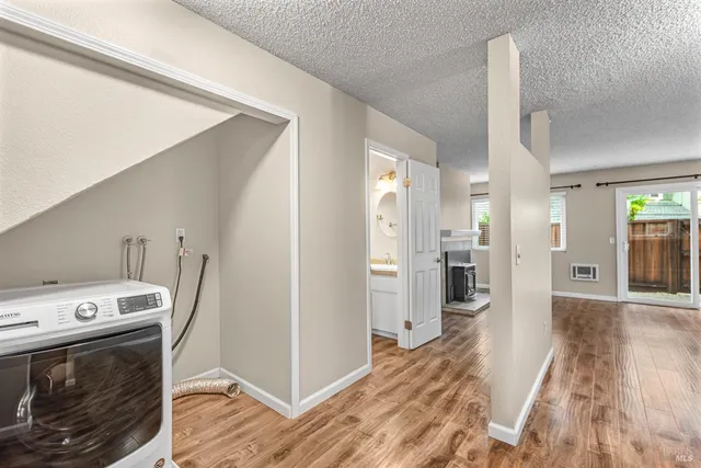 a view of a kitchen with refrigerator and wooden floor