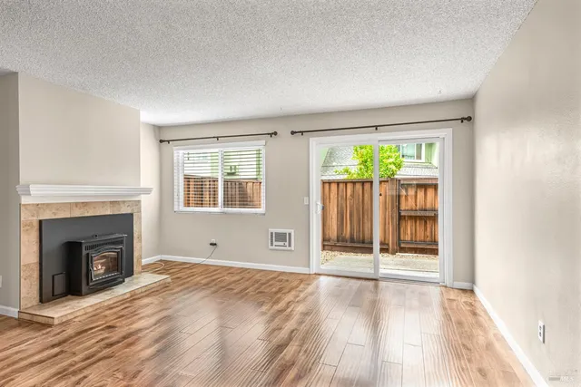 a view of empty room with wooden floor and fireplace