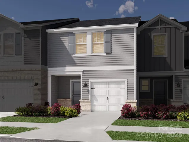a front view of a house with a garden and plants