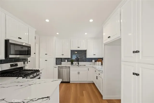 a kitchen with a sink a stove and cabinets