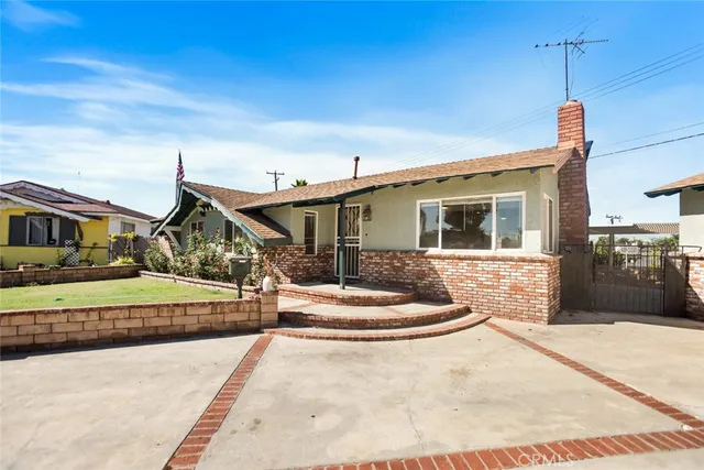 a front view of a house with a garden and parking