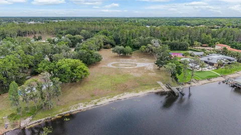 an aerial view of a house with a yard and lake view