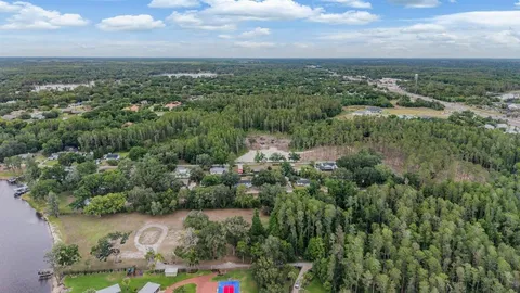 an aerial view of residential houses with outdoor space and trees