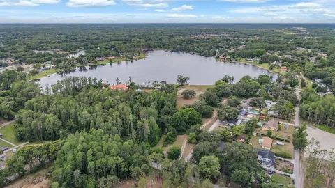an aerial view of city and river surrounded with trees