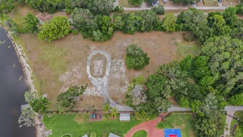 an aerial view of a house with a yard and lake view