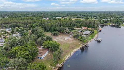 an aerial view of a house with a yard and lake view