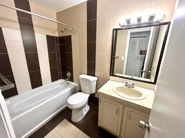 a bathroom with a sink a toilet a mirror and shower