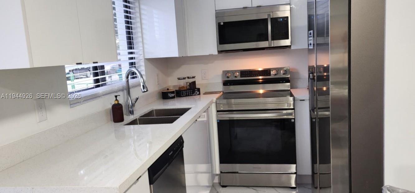 8012 Northwest 14th Place, Unit A Miami, FL 33147 - Photo 2 of 12 a kitchen with a stove and a microwave