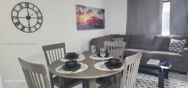 a view of a dining room with furniture a rug and wooden floor
