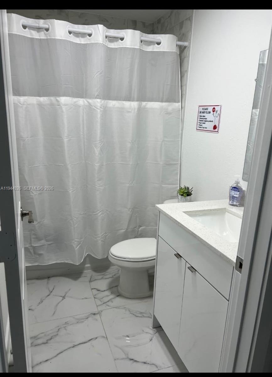 8012 Northwest 14th Place, Unit A Miami, FL 33147 - Photo 7 of 12 a bathroom with a sink a toilet and shower