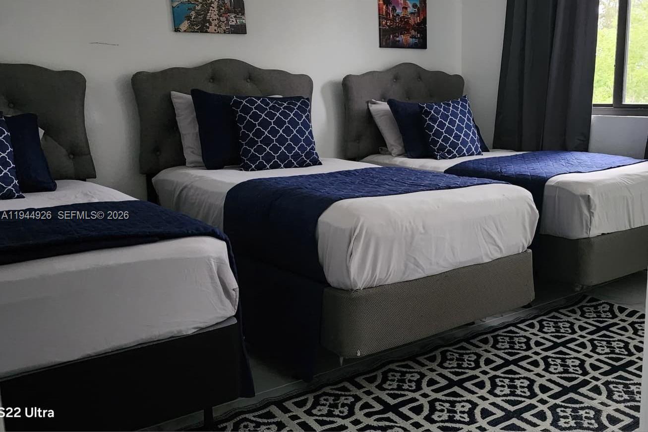 8012 Northwest 14th Place, Unit A Miami, FL 33147 - Photo 8 of 12 a bedroom with bed and window