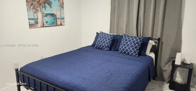 a bed sitting in a bedroom next to a window