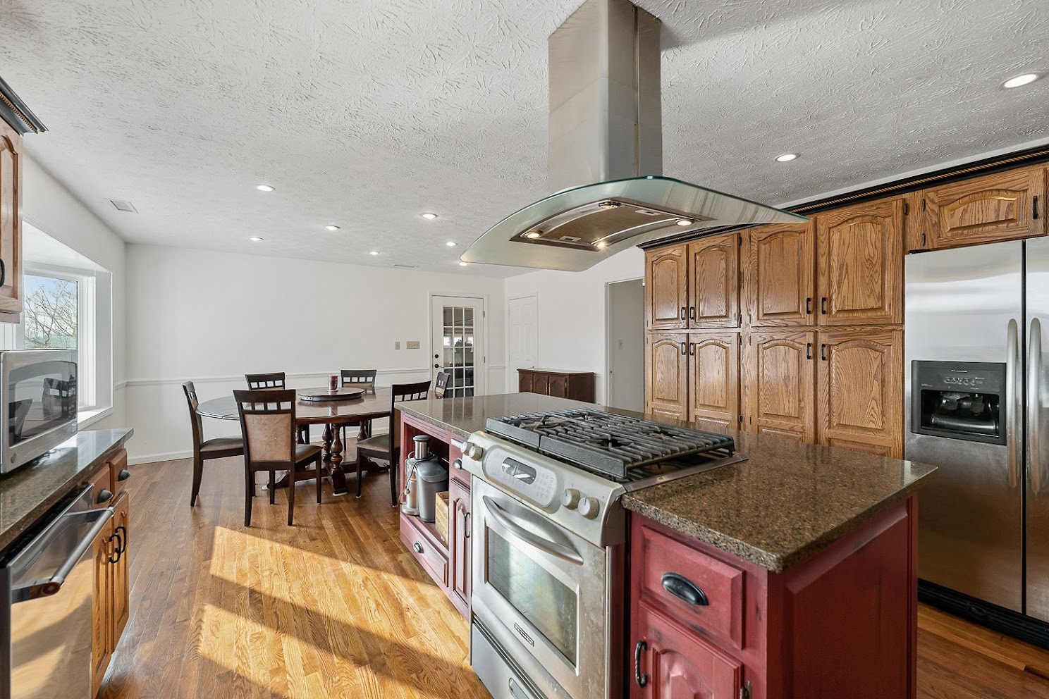 416 O'Neal Road Livingston, TN 38570 - Photo 10 of 22 a kitchen with stainless steel appliances granite countertop a stove a refrigerator a kitchen island a dining table and chairs with wooden floor