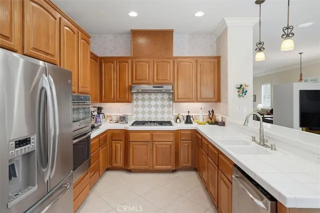 a kitchen with stainless steel appliances granite countertop a sink refrigerator and cabinets