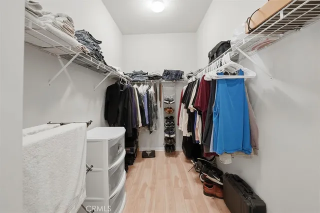 a view of walk in closet with clothes and shoes