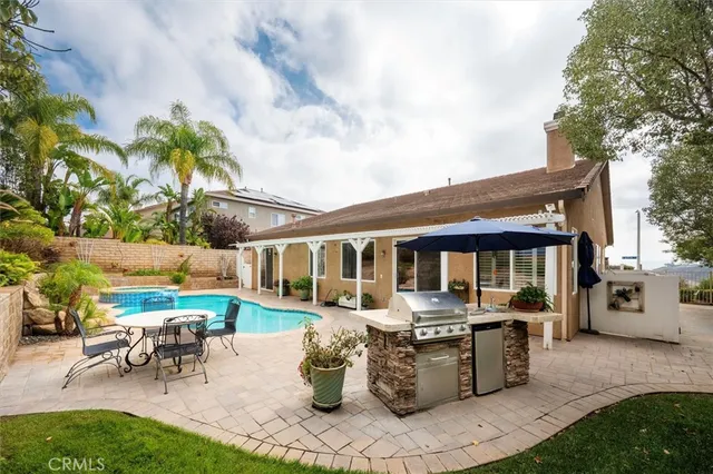 a view of a patio with table and chairs potted plants and a large tree