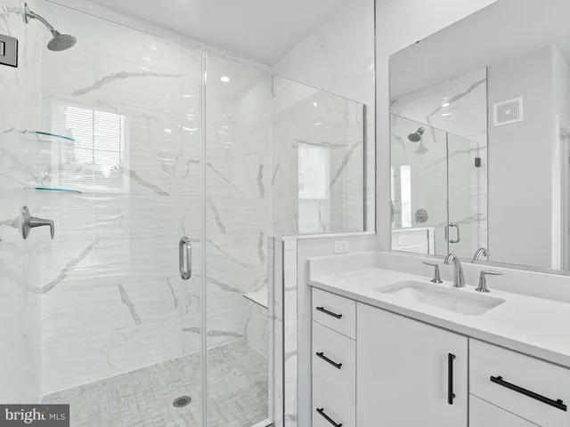 a bathroom with a shower sink and mirror