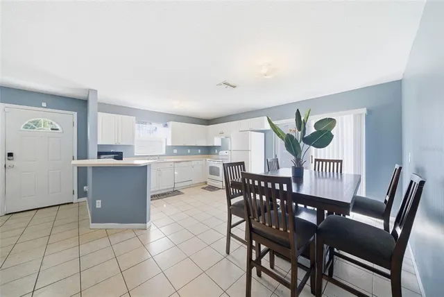 a view of kitchen with granite countertop cabinets table and chairs