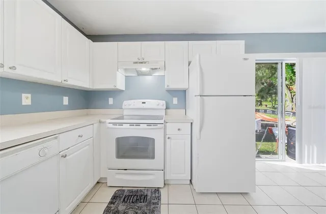 a kitchen with a white stove and white cabinets