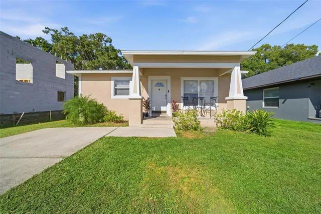 a front view of a house with a yard and potted plants