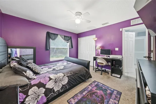 a bedroom with a bed a chandelier and dresser