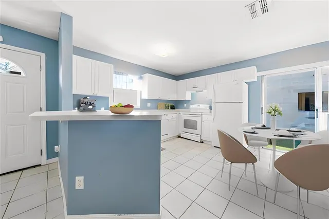 a kitchen with stainless steel appliances a stove a sink a oven a dining table and chairs