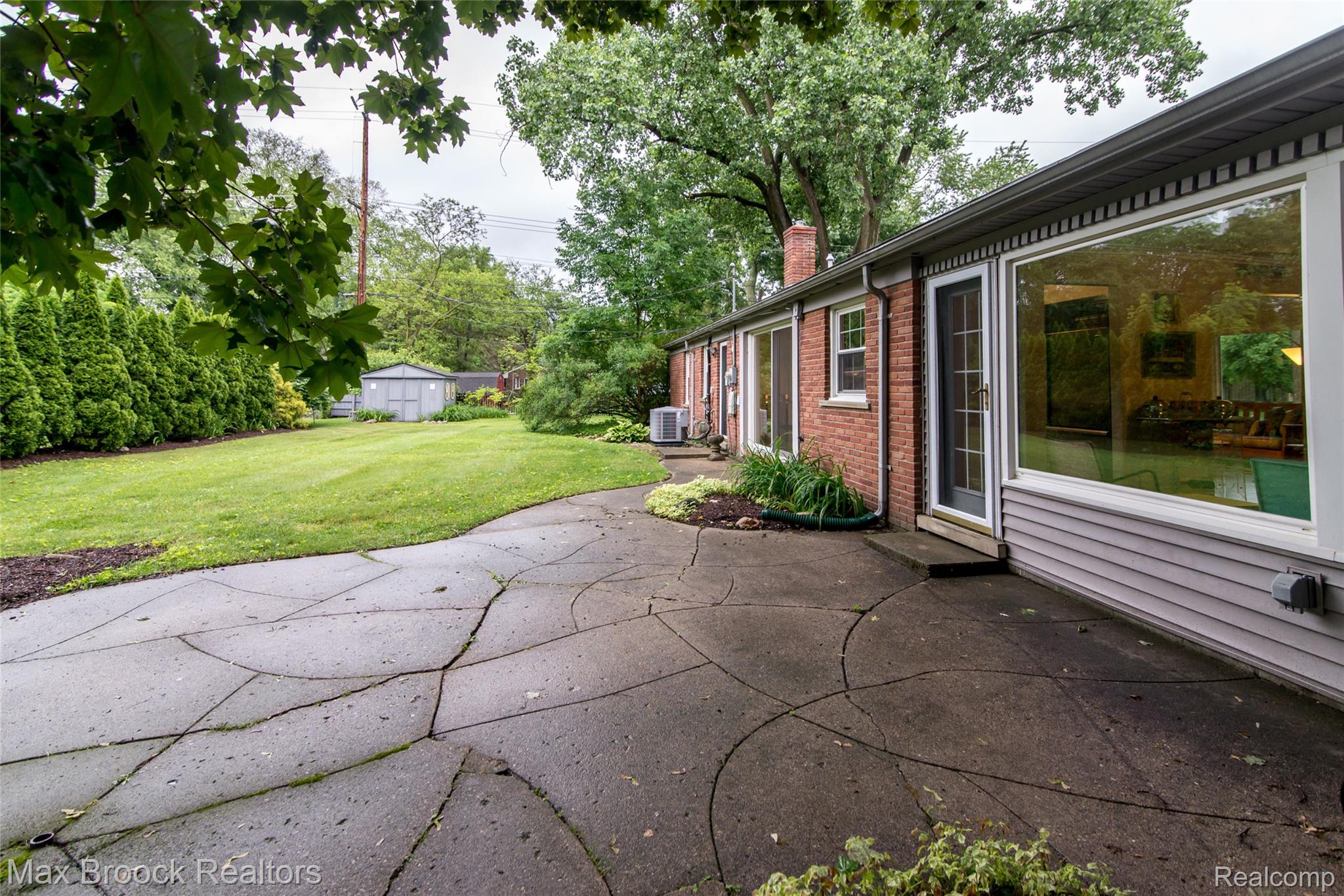 6799 East Dartmoor Road West Bloomfield, MI 48322 - Photo 27 of 36 Expansive green lawn with mature perimeter plantings and a rear storage shed