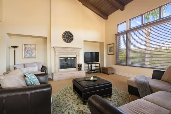 a living room with furniture a fireplace and a large window