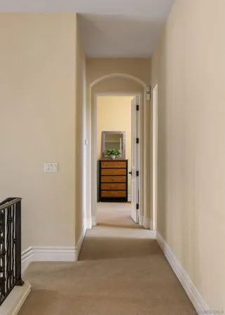 a view of a hallway with wooden floor and a white cabinet