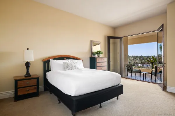 a large bed sitting in a bedroom next to a window