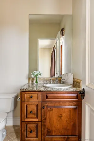 a bathroom with a granite countertop sink and a mirror