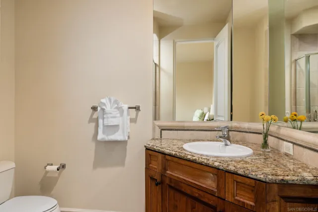 a bathroom with a granite countertop sink and a mirror