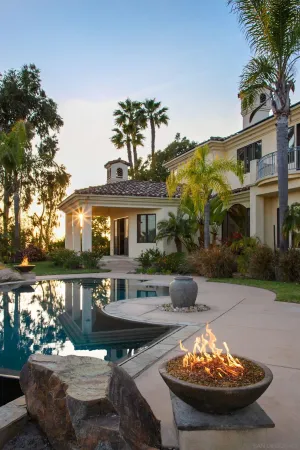 a view of a house with backyard water fountain and sitting area