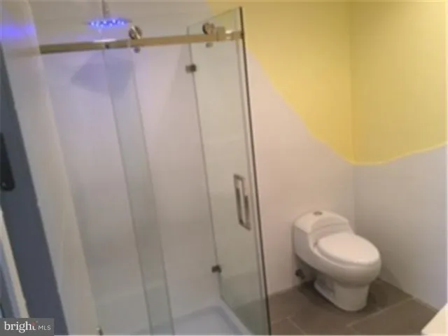 a white toilet sitting next to a shower