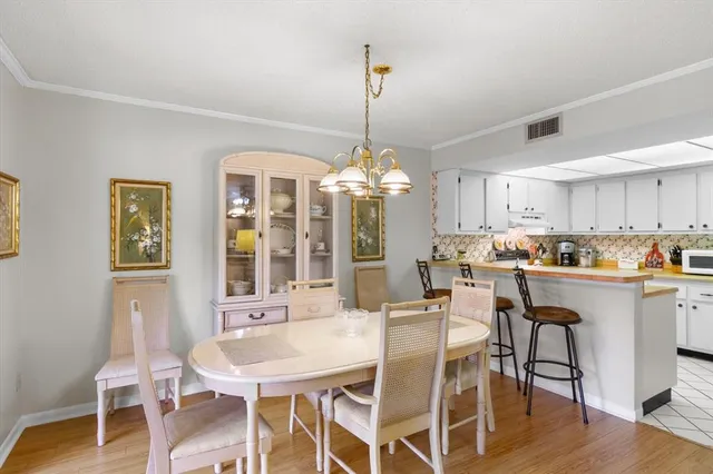 a dining room with furniture a chandelier and wooden floor