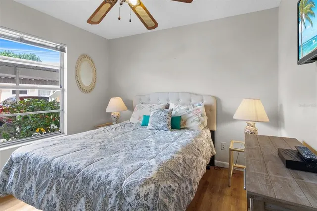 a bedroom with a bed wooden floor and window