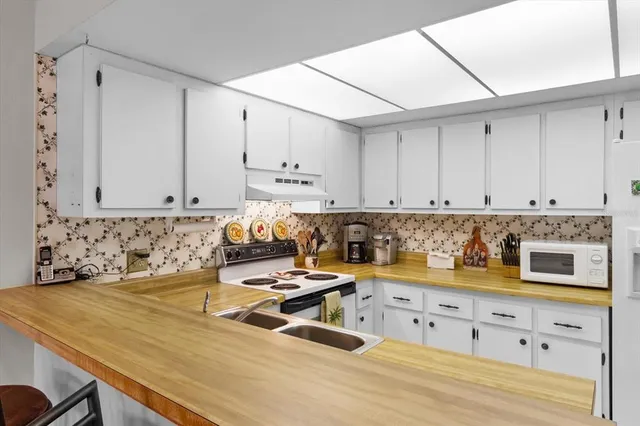 a kitchen with a stove a sink and cabinets